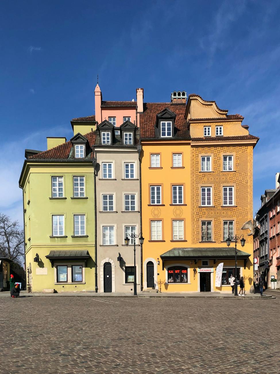 people walking near yellow concrete building, things to do in warsaw poland