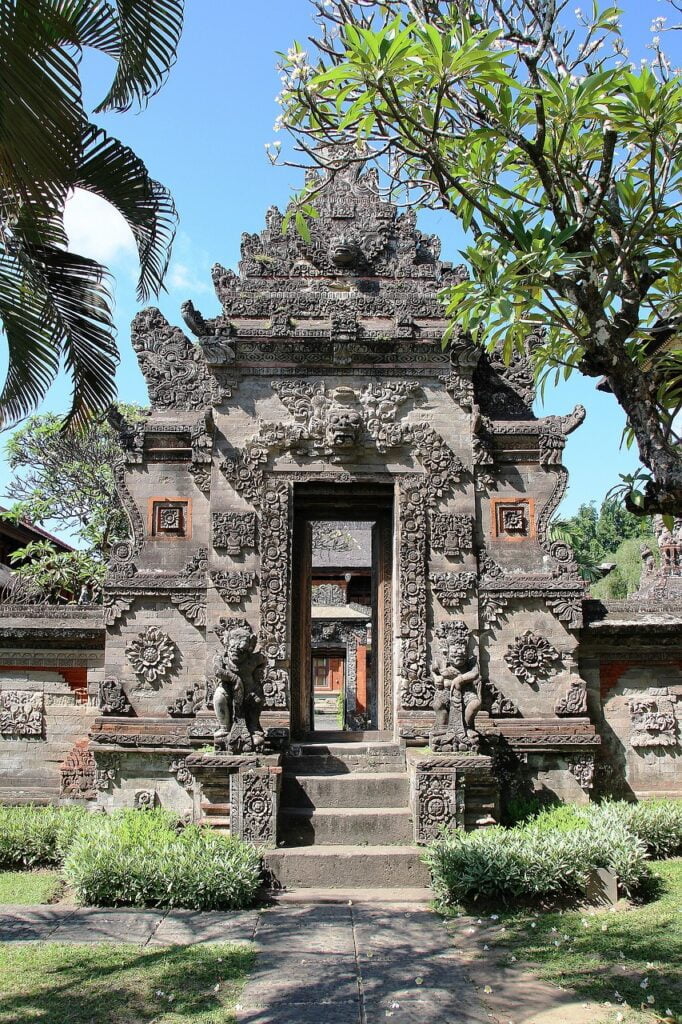 Stone entrance to temple with tree in background, Bali, Indonesia.