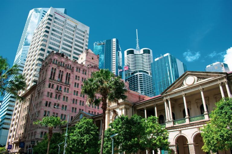 Brisbane cityscape featuring high-rise buildings and palm trees.