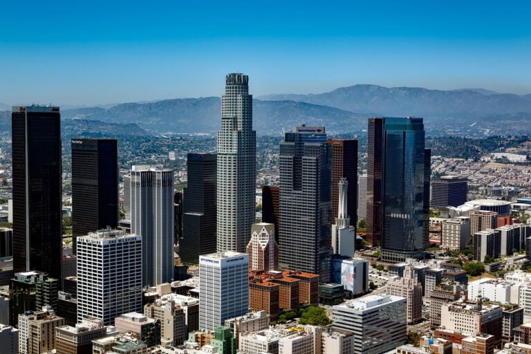 Aerial view of Los Angeles skyline with skyscrapers and city lights at night.