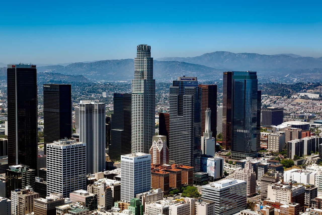 Aerial view of Los Angeles skyline with skyscrapers and city lights at night.