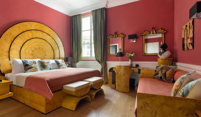 Bedroom with large bed and wooden headboard at La Maison du Sage in Florence, Italy.