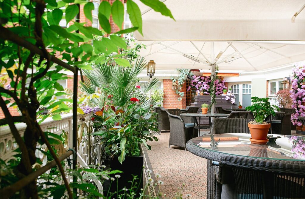 Outdoor seating area with table, chairs, and plant at St. Ermin's Hotel, Autograph Collection in London.