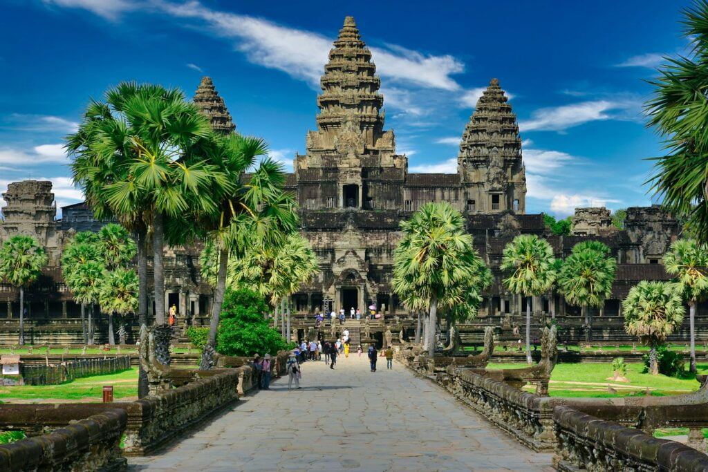 people walking on park near trees and building during daytime in cambodia