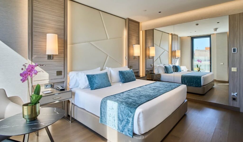 Spacious hotel room with two beds and a large mirror at Best Hotels in Madrid - VP Plaza España Design.