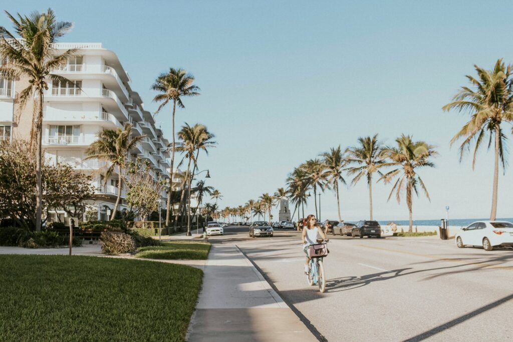 man in white t-shirt and blue denim jeans walking on gray concrete pathway during daytime - Things to Do in Palm Beach