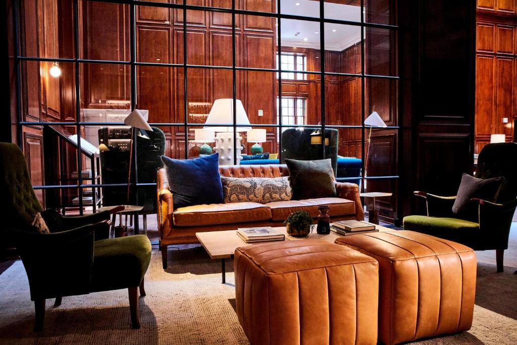 The lobby of The Adolphus, Autograph Collection hotel in Dallas. Luxurious leather furniture and large windows.