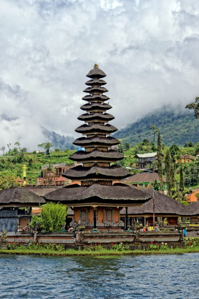 brown and black concrete building near body of water under cloudy sky - Asia luxury resorts i n bali