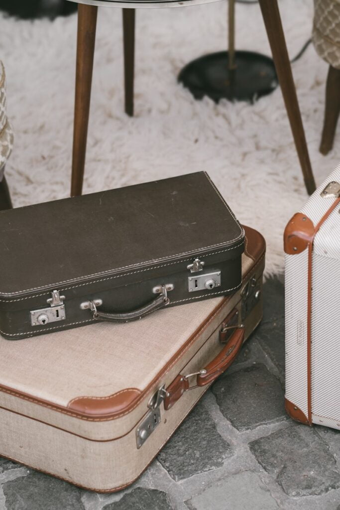 Three suitcases on a rug in front of a chair. Ideal for a solo travel packing list.