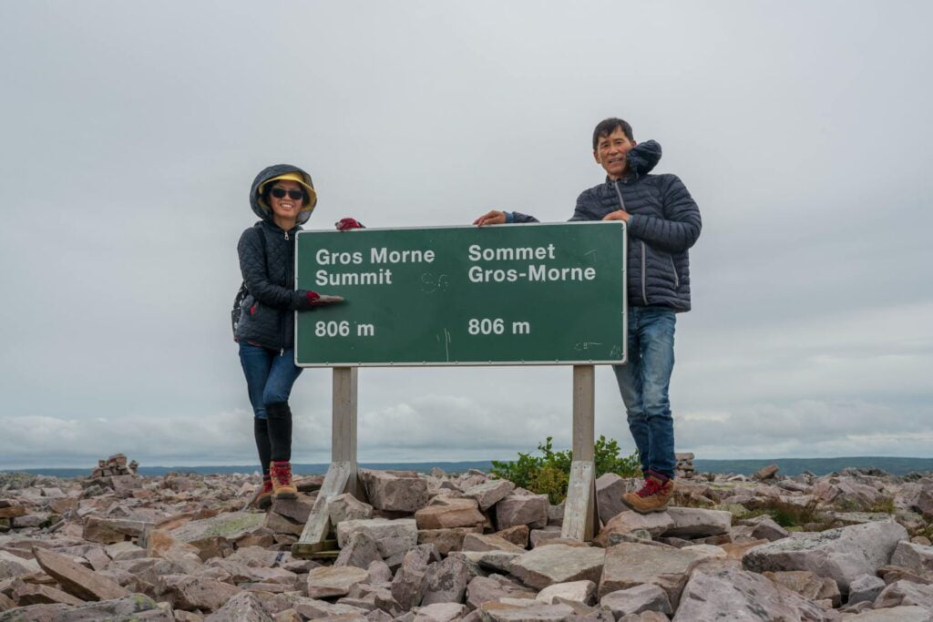 Woman and Man Posing with a Sign at Gros-Morne Mountain, Canada