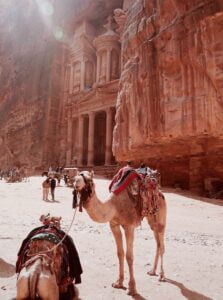 people riding on camel near brown concrete building during the day—places to visit in the middle east