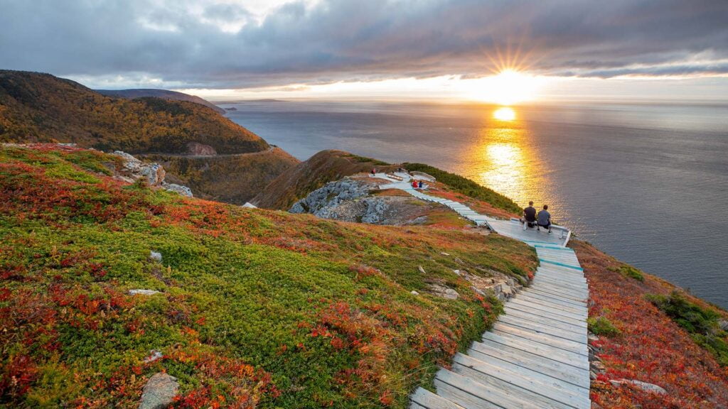 Scenic sunset over ocean, wooden path to hilltop. Image by novascotia.com. Top 10 hiking trails in Canada.