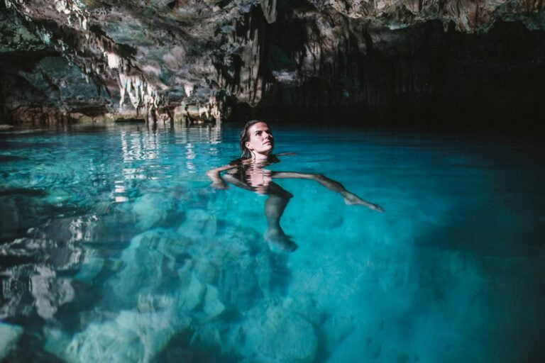 woman in black bikini swimming on water - Rangko Cave from Labuan Bajo