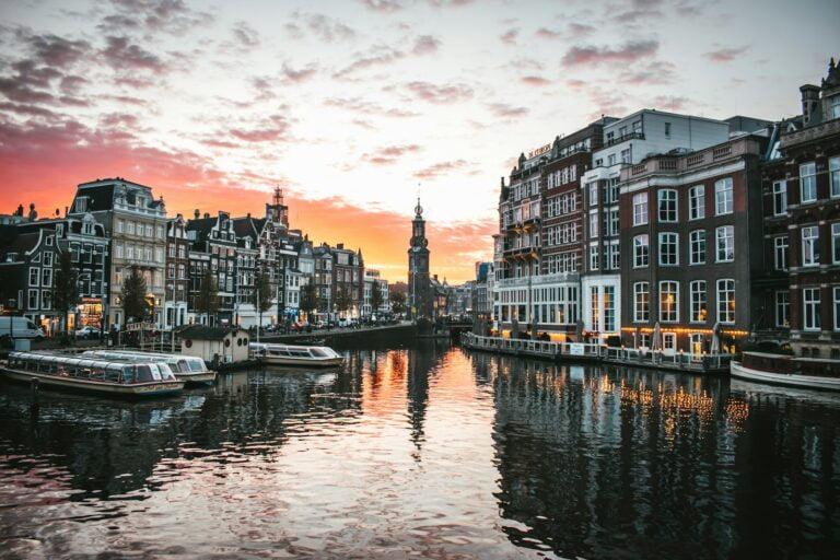 white boat on river between buildings during -Top 10 Things to Do in Amsterdam