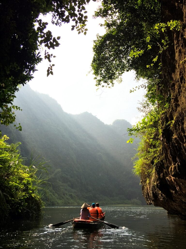 group of people on boat paddling in Ninh Binh