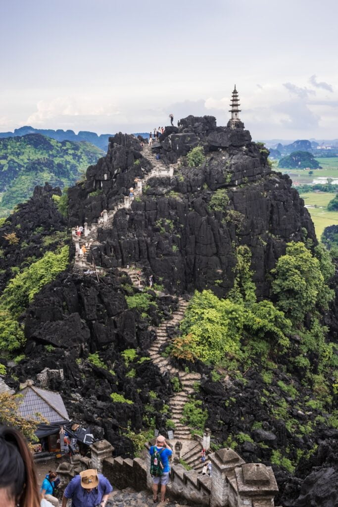 people walking on stairs during daytime in Mua Cave, Ninh Binh day trip