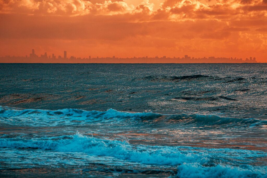 Ocean Waves Under Orange Sky during Sunset